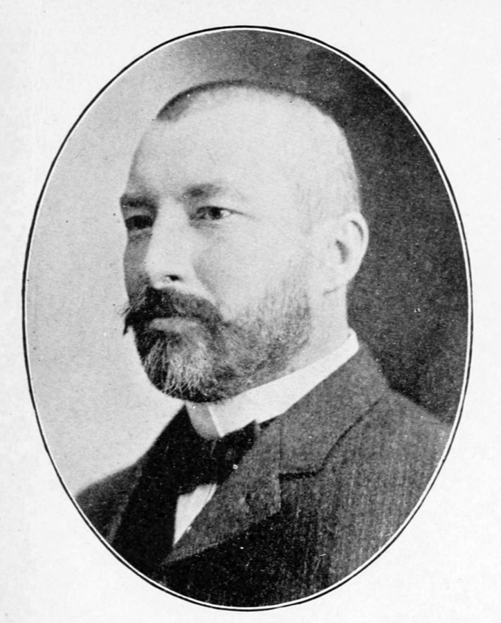 A bearded man in a suit with a bow tie, shown in an oval frame, looking to the left.