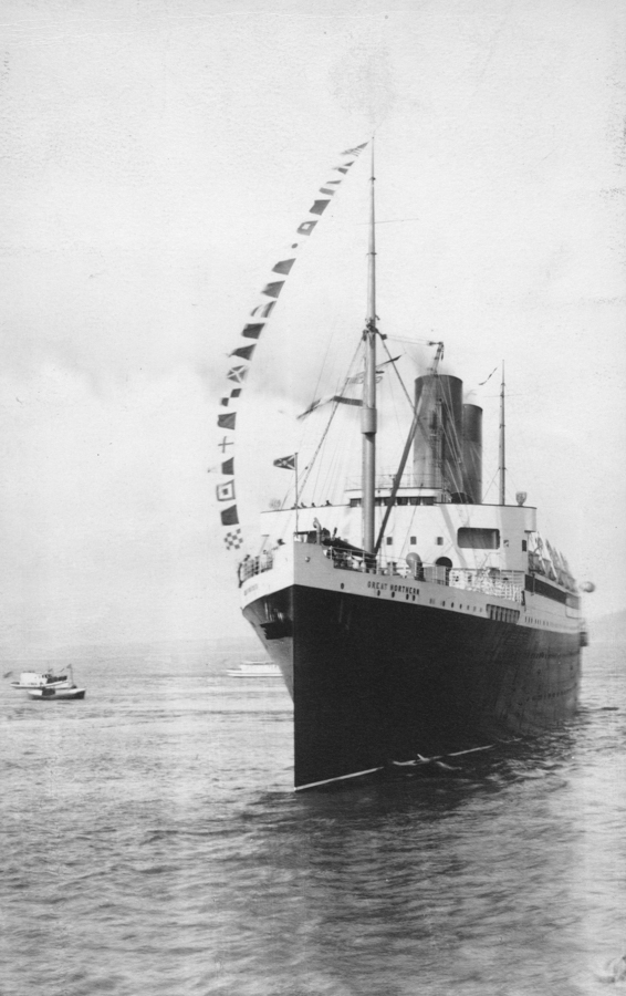 A large ship named "Great Northern" is sailing in the water, with flags strung along its mast. A smaller boat is visible in the background on the left. The scene depicts a calm maritime setting.