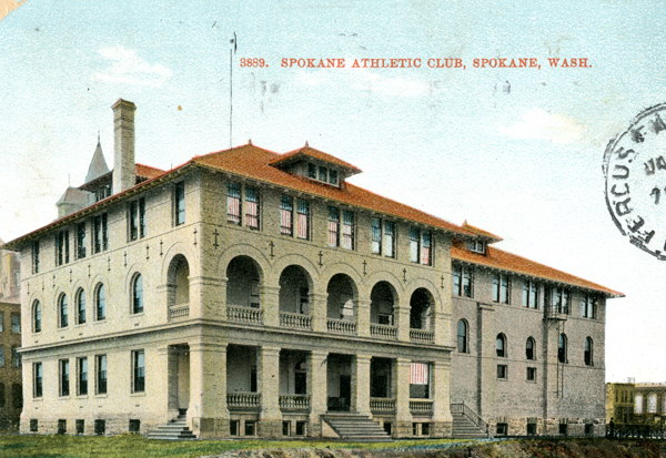 A large building with a red roof and arches, featuring multiple stories and windows. The text reads 