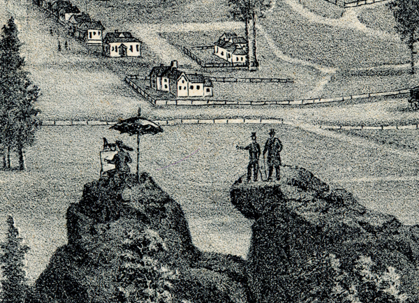 Two men standing on a rocky outcrop, one pointing, with a few houses and trees in the background. On an adjacent rock, a person sits under an umbrella next to an easel. More houses and a path are visible in the distance.