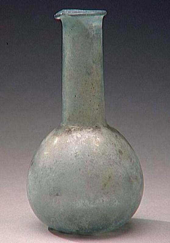 Picture of a glass bottle with a rounded bottom and longer neck, a small lip at the top, and a blue to green hue color