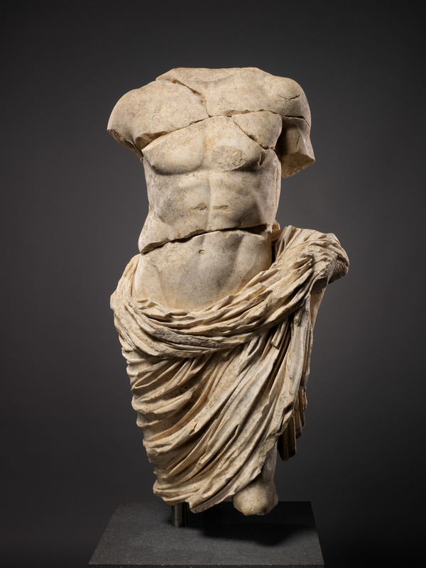 A Marble statue depicting the a man without arms, legs or head.
