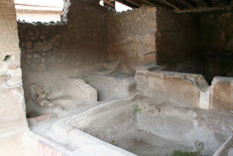Image showing the interior of a Fullonica workshop, with a soaking basin and the small treading stalls