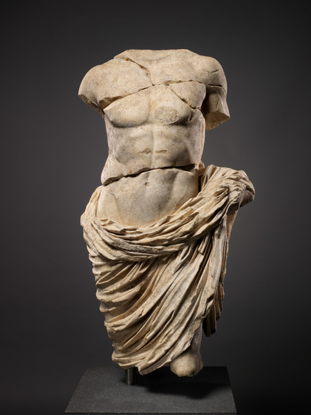A Marble statue depicting the a man without arms, legs or head.